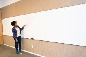 woman-wearing-black-blazer-holding-pen-pointing-white-marker-1181397
